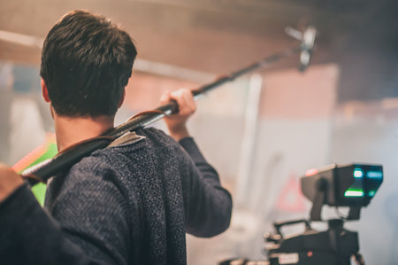 Behind the scene. Sound boom operator hold microphone fisher on the set