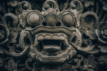 Closeup portrait of stone traditional sculpture art form incorporated into temples, which demonstrate the influences of Hindu Buddhist culture. Bali, Indonesiaの写真素材