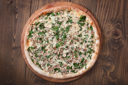 Fresh italian mushroom pizza on wooden background, top view. Delicious italian fast foodの写真素材