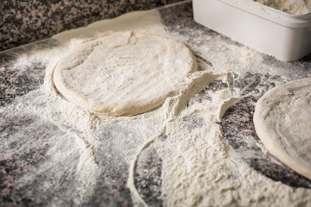Preparing fresh raw dough for pizza on kitchen table. Cooking processの写真素材