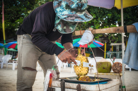 KOH SAMUI, THAILAND - 22. MAY 2018. Local man selling fresh fruit on a beach. Lot of vegetables and...