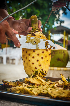 Local man preparing fresh fruit on a tropical beach. Close upの写真素材
