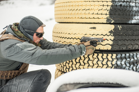 Combat gun shooting training from behind and around cover or barricade. Advanced fighting tactical shooting courses on shooting rangeの写真素材