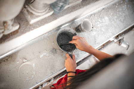 Female worker plastering old building wall using cement plaster mix of cement and sand at the construction siteの写真素材