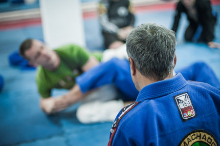 BELGRADE, SERBIA - 13. OCTOBER 2019. Sensei master Avi Nardia in traditional kimono, demonstrate BJJ Brazilian jiu-jitsu ground control and finish technique to his students on Kapap Krav Maga seminarのeditorial素材