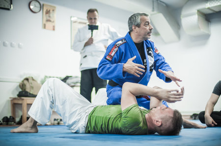 BELGRADE, SERBIA - 13. OCTOBER 2019. Sensei master Avi Nardia in traditional kimono, demonstrate BJJ Brazilian jiu-jitsu ground control and finish technique to his students on Kapap Krav Maga seminarのeditorial素材