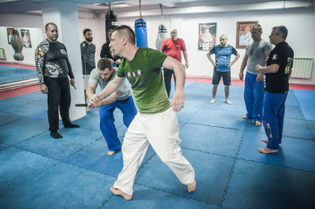 BELGRADE, SERBIA - 13. OCTOBER 2019. Kapap Krav Maga Sensei master instructor Avi Nardia demonstrates combat knife attack self-defense technique to large group of students on Kapap Krav Maga seminarのeditorial素材