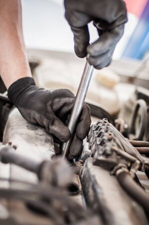 Car master mechanic repairer checking, testing and changing spark plugs on the car in auto vehicle workshopの写真素材