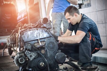 Removed engine from car. Two car master auto mechanic repairer chacking and repair car engine in service workshopの写真素材