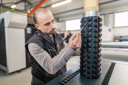 Technician doing post production, finishing and processing of the large 3d model printed on modern...