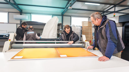 Large group of worker printmaker technician operator works in digital printing press hall and...