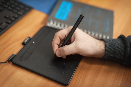 Close-up detail view of graphic designers and 3d program animators hand, work on graphic tablet and...