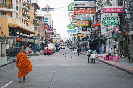 BANGKOK, THAILAND - 29. MAY 2018. An unknown Buddhist monk walks barefoot down the city street. Khao San Road is popular tourists street in Bangkok Thailand. Day editorial shotのeditorial素材