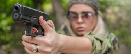 Attractive soldier woman practice shooting and gun point aim to attacker. Close-up pistol pointing...