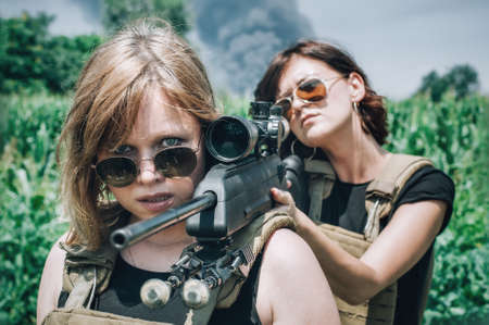 Female soldier shooting with sniper rifle. Woman with weapon. Firearm army shooting and tactical training. Outdoor shooting rangeの写真素材