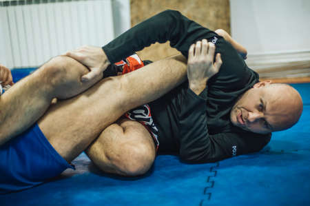 BJJ Brazilian jiu-jitsu ground fight training combat sparing. Leg lock kneebar submission control techniqueの写真素材