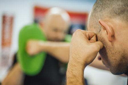 Instructor holds focus mitts. Boxing kick training and demonstration. Martial arts practiceの写真素材