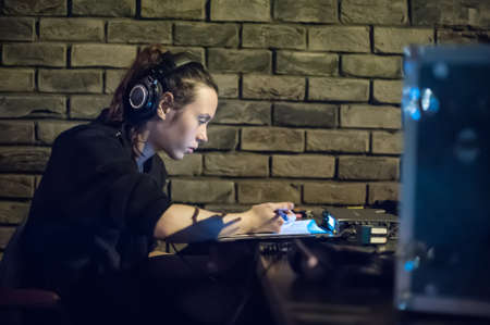 Behind the scene. Sound director and technician check equipment. Film recording indoorの写真素材