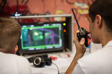 Behind the scenes. Film director oversees and control the shooting of the film on the lcd panel from the outdoor film montage editing studio. Analog and digital video editingの写真素材