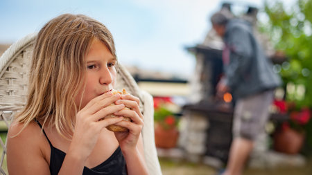 BBQ grilling party. Beautiful girl enjoying barbecue at outdoors. Food, people and family time conceptの写真素材