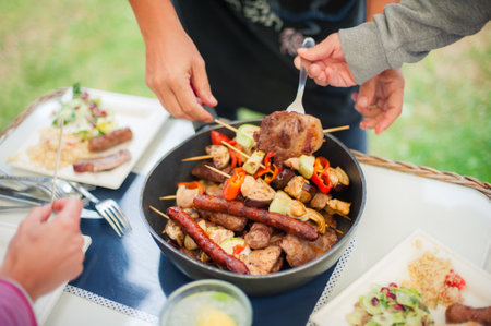 BBQ grilling party. Close up of people hands taking barbecue and grilled vegetables skewersの写真素材