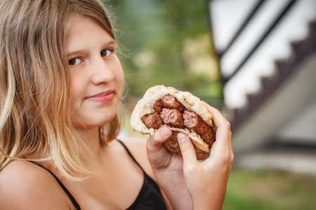 BBQ grilling party. Beautiful girl enjoying barbecue at outdoors. Food, people and family time conceptの写真素材