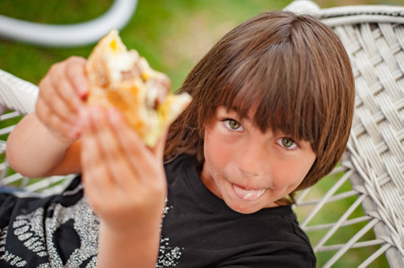 BBQ grilling party. Happy boy enjoying barbecue at outdoors. Food, people and family time conceptの写真素材