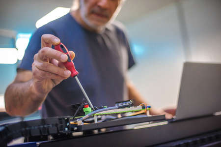 Field service maintenance engineer technician electrician inspect and control machine hardware and software system with laptop computer. Electric installationの写真素材