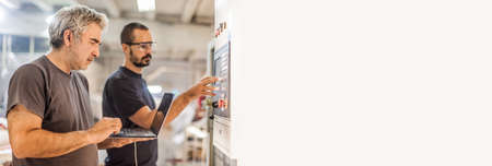 Two field service maintenance engineer technician electrician inspect and control machine hardware and software system with laptop computer. Electric installationの写真素材