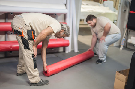 Technician worker operator changes the paper roll on large premium industrial printer and plotter...