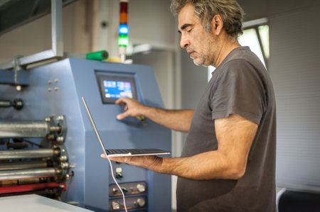 Field service maintenance engineer technician electrician inspect and control machine hardware and software system with laptop computer. Electric installationの写真素材