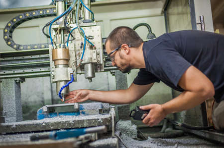Engineer worker technician operating with CNC milling metal engraving machine in factory workshop.の写真素材