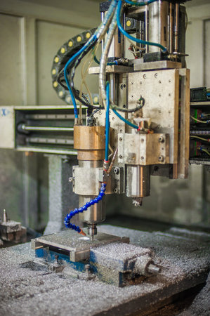 Close-up detail view of CNC milling metal engraving machine in factory workshop