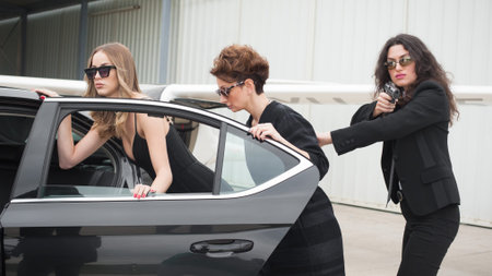 Professional armed team of female and male bodyguards protect celebrity person in car limousine....