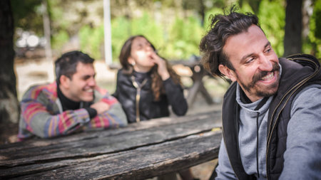 Group of relaxed and smiling happy young friends, female and male, smoking cannabis marijuana ganja...