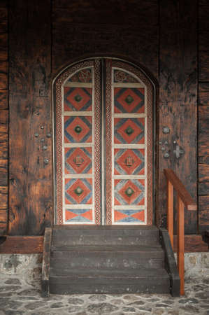 Detail view of old massive huge church wooden ancient door. Secret mystery entrance. Traditional gothic grunge vintage style. Medieval security and safetyの写真素材