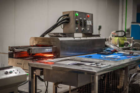 Closeup view of automatic heater stove heating PVC machine in factory production workplace. Industrial working operating processの写真素材