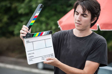 Filming on location. Man holding a clapperboard in front of the camera, the filming process. Scene on locationの写真素材