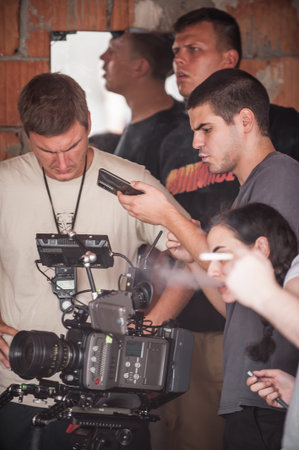 Behind the scenes. Film crew team shooting movie scene on outdoor location. Group filmmaking set...