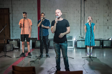 Behind the scenes. Rehearsal at theatre. Large group of actors practicing for singing performance...