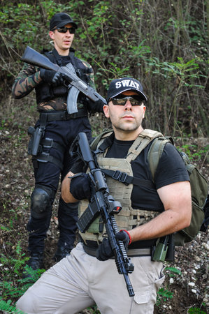 Army soldiers shooting with rifle machine gun in the forest. Nature outdoor military combat training
