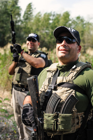 Full armed swat special forces army soldier in combat camouflage uniform. Firearm shooting and...