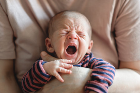 Sweet and cute small little newborn baby is hungry and upset and cry strongly inviting her parents to feed her and solve her problem. Stomach crampsの写真素材