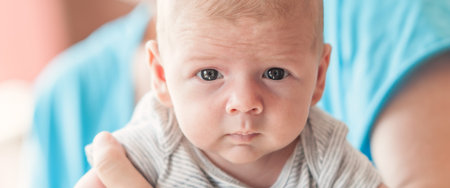 Close-up detail portrait of cute little peaceful newborn baby boy child face with beautiful open...