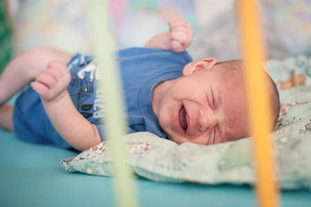 Sweet and cute small little newborn baby is hungry and upset and cry strongly inviting her parents to feed her and solve her problem. Stomach crampsの写真素材