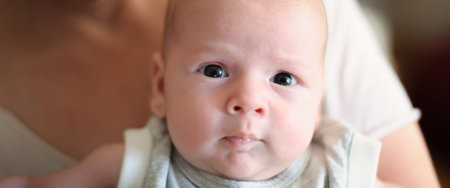 Close-up detail portrait of cute little peaceful newborn baby boy child face with beautiful open...