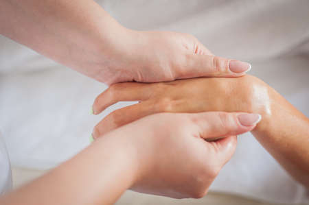 Woman at a health spa having a hand massage and acupressureの写真素材