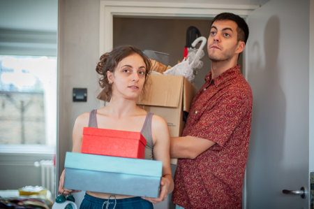 Young cheerful excited couple standing at the door of their new apartment. Moving, happiness, life together.の写真素材