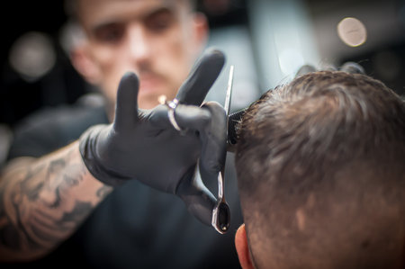 Modern urban hairdresser cut hair with hair scissors in professional hairdressing salon and studio. Close-up detail viewの写真素材