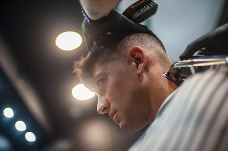 Modern urban hairdresser cut hair with hair trimmer in professional hairdressing salon and studio. Close-up detail viewの写真素材